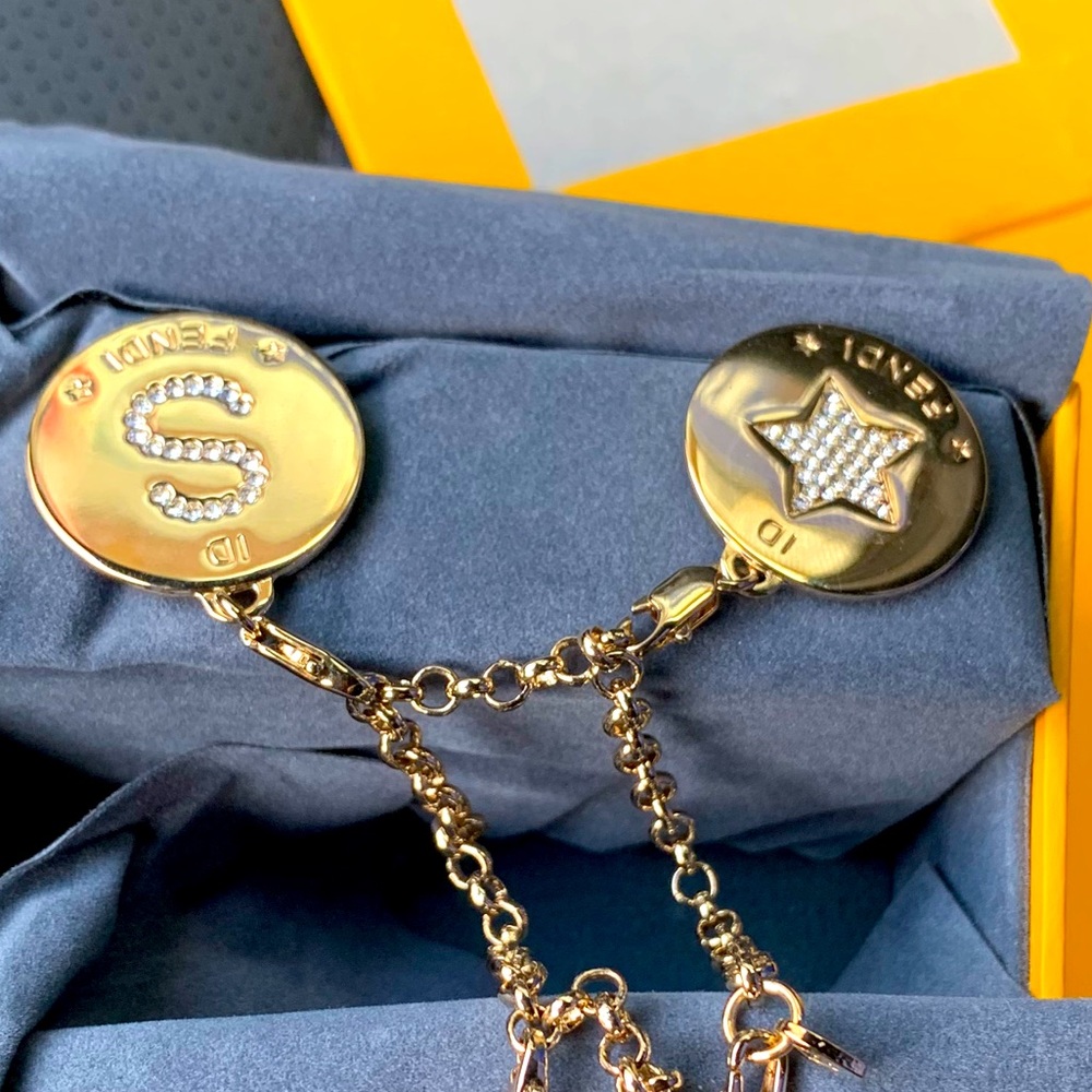 Fendi ladies gold bracelet with 3 charms.